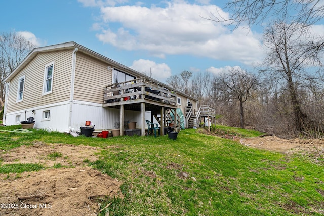 back of property featuring a deck, a yard, and stairs