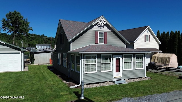 view of front of home featuring an outdoor structure, a shingled roof, a garage, and a front yard