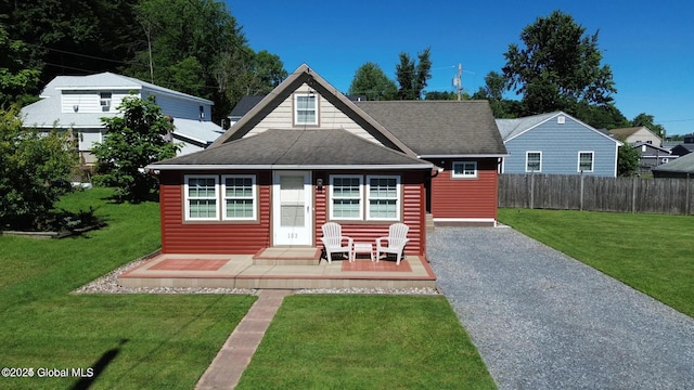 bungalow-style home featuring fence, a wooden deck, a shingled roof, and a front yard