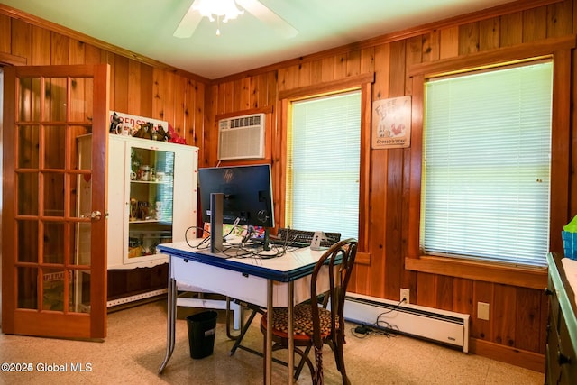 home office with crown molding, ceiling fan, wood walls, light floors, and a baseboard heating unit