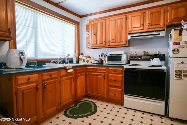 kitchen with brown cabinetry, freestanding refrigerator, electric range oven, and under cabinet range hood
