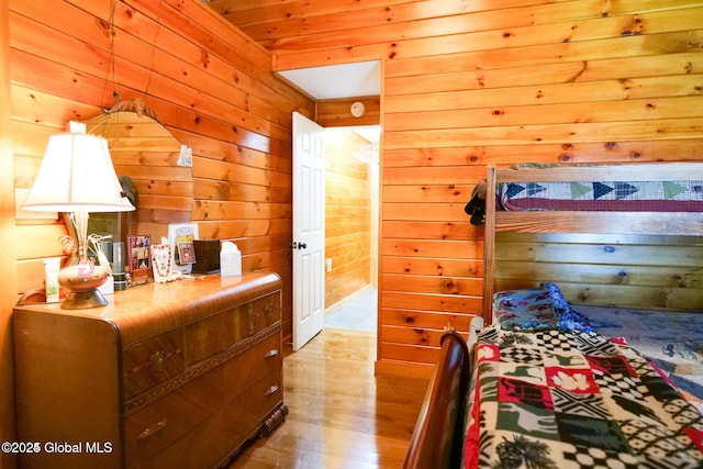 bedroom featuring wood walls and wood finished floors