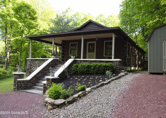 log-style house featuring a porch and log siding