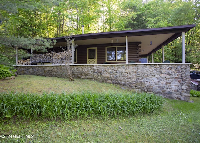 view of front of property with stone siding and log exterior
