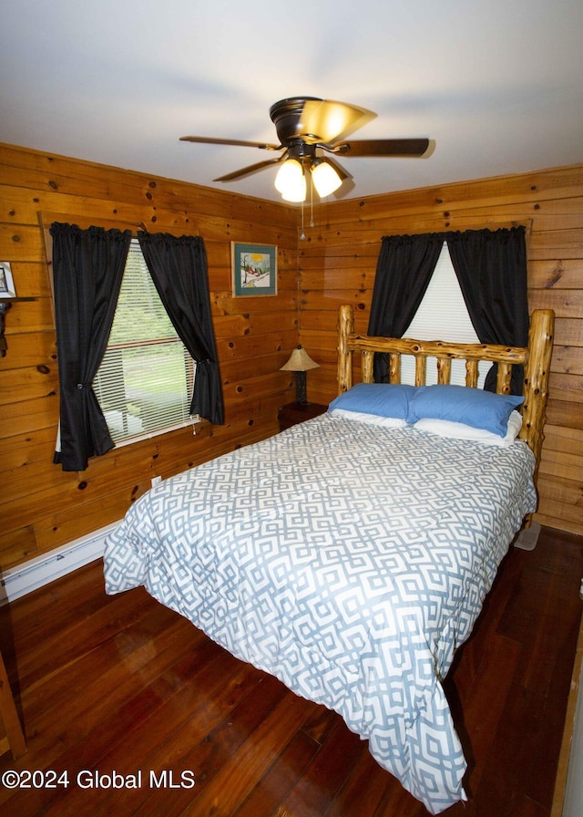 bedroom with wooden walls, ceiling fan, and wood finished floors