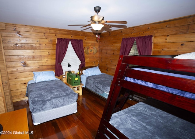 bedroom with wooden walls, wood finished floors, and a ceiling fan