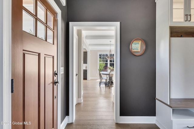 interior space with a chandelier, baseboards, and wood finished floors