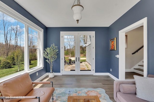 doorway featuring wood finished floors, french doors, baseboards, and stairs