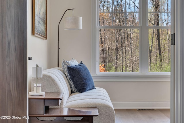 sitting room featuring baseboards, visible vents, and wood finished floors