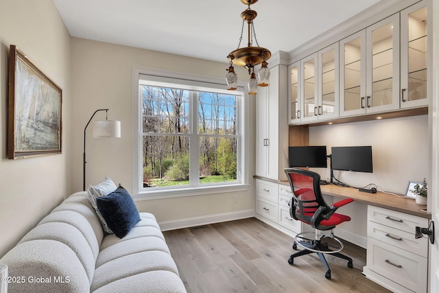 office space featuring built in desk, light wood-type flooring, visible vents, and baseboards