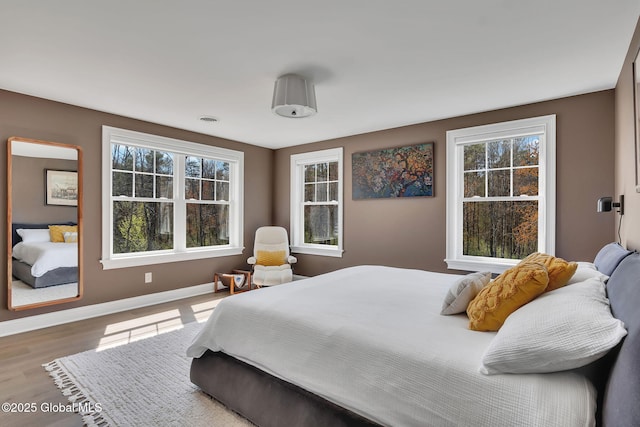 bedroom with baseboards and wood finished floors