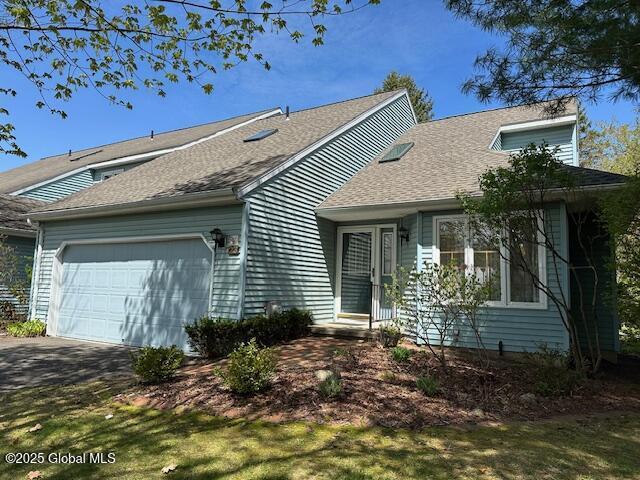 single story home with roof with shingles, an attached garage, and aphalt driveway