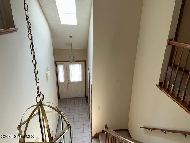 doorway with a skylight and light tile patterned floors
