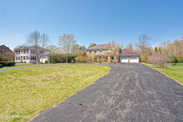 view of front facade with an attached garage, a front yard, and aphalt driveway