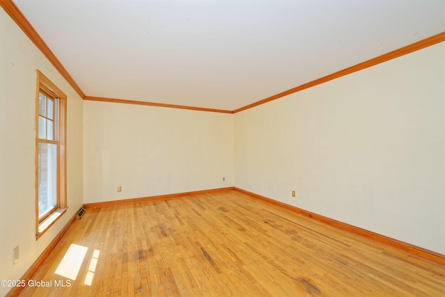 empty room with light wood-type flooring, ornamental molding, and baseboards