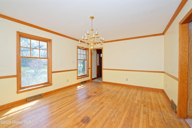 empty room featuring plenty of natural light, light wood finished floors, and a notable chandelier