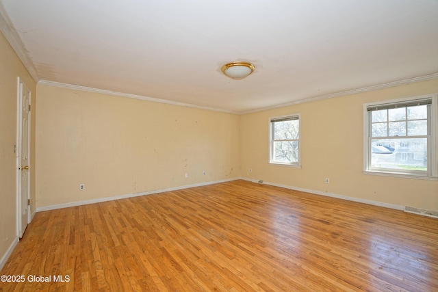 spare room with crown molding, visible vents, and light wood-style flooring