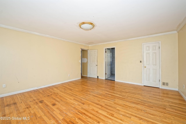 unfurnished room with visible vents, ornamental molding, baseboards, and light wood-type flooring