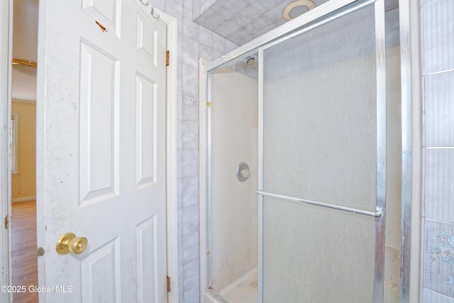 bathroom featuring a stall shower and wood finished floors