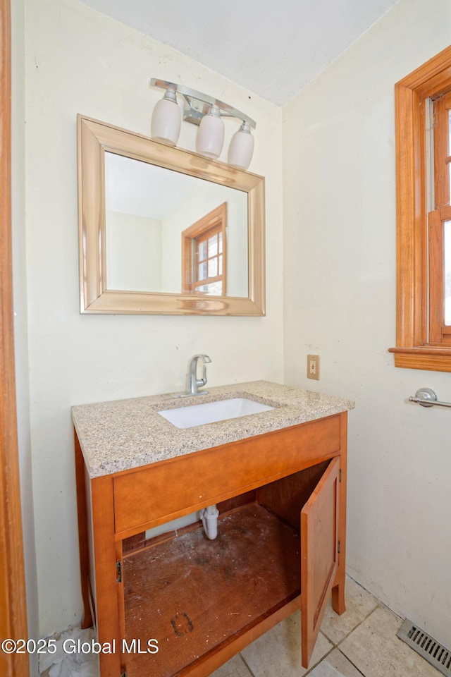 bathroom with visible vents, a healthy amount of sunlight, tile patterned flooring, and vanity