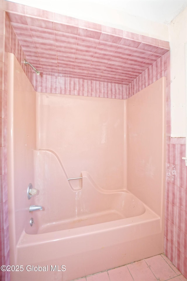 full bath with washtub / shower combination and tile patterned floors