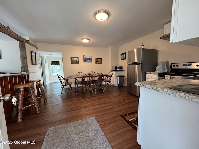 dining space featuring dark wood-type flooring and baseboards