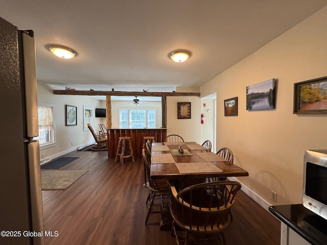 dining room with a ceiling fan, dark wood finished floors, and baseboards