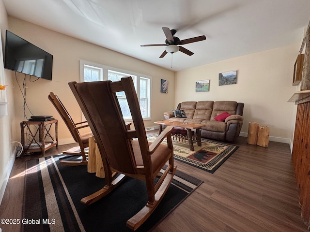 living area with ceiling fan, baseboards, and dark wood-type flooring
