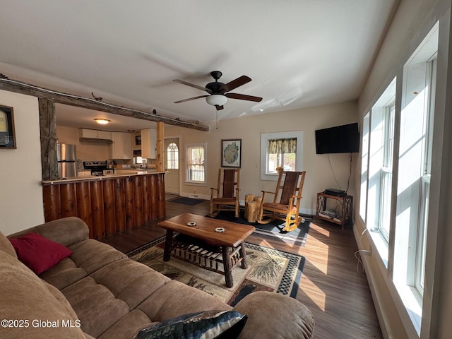 living room with wood finished floors, a ceiling fan, and baseboards