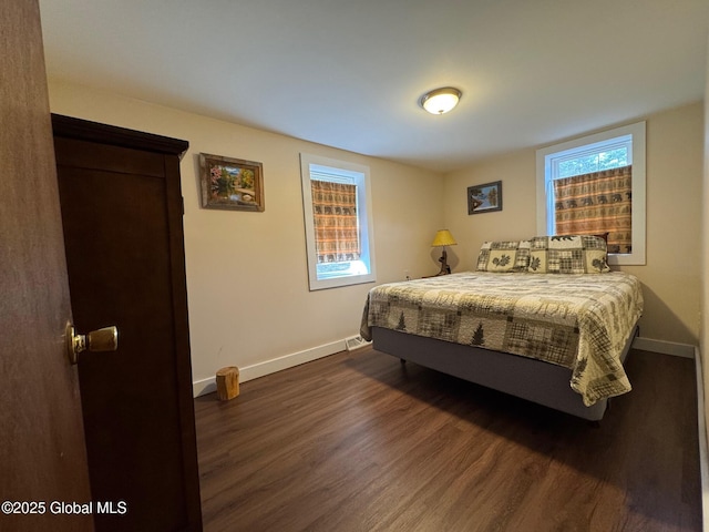 bedroom with dark wood-style flooring and baseboards