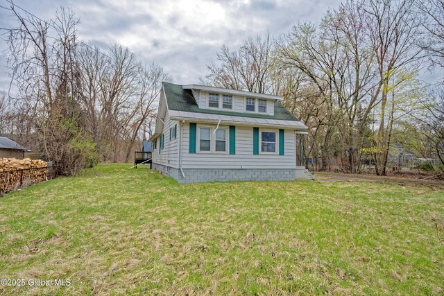 view of side of property featuring fence and a lawn