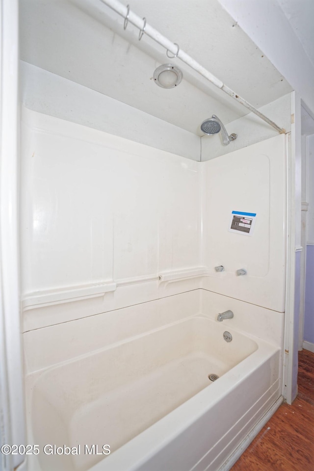 full bath featuring washtub / shower combination and wood finished floors