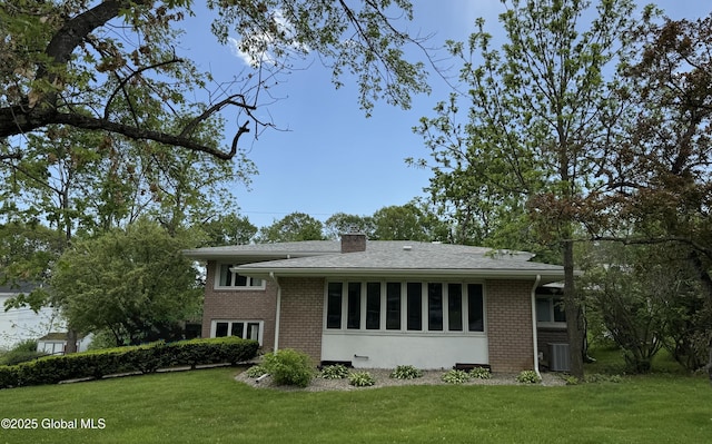 15 Campus View Dr, Colonie, NY 12211 - view of front of house with brick siding, a front yard, cooling unit, and a chimney
