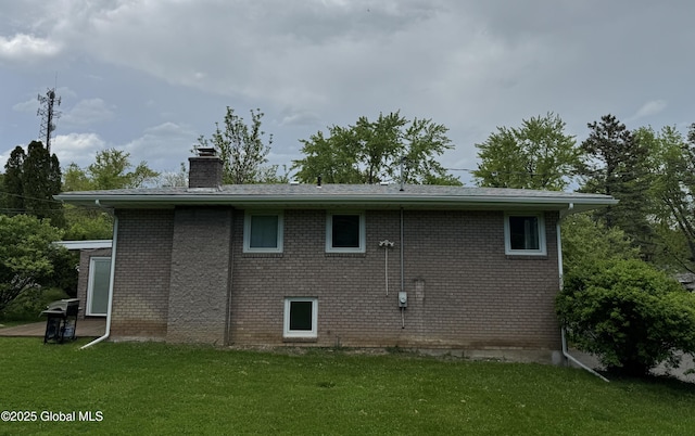 15 Campus View Dr, Colonie, NY 12211 - rear view of house featuring a chimney, a lawn, and brick siding