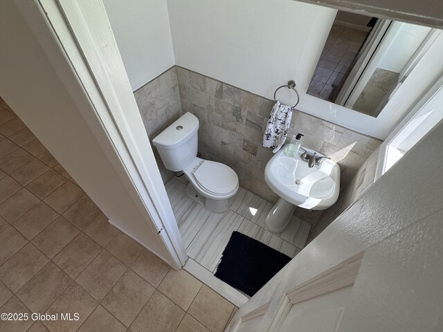 15 Campus View Dr, Colonie, NY 12211 - bathroom featuring toilet, tile patterned floors, tile walls, a sink, and wainscoting