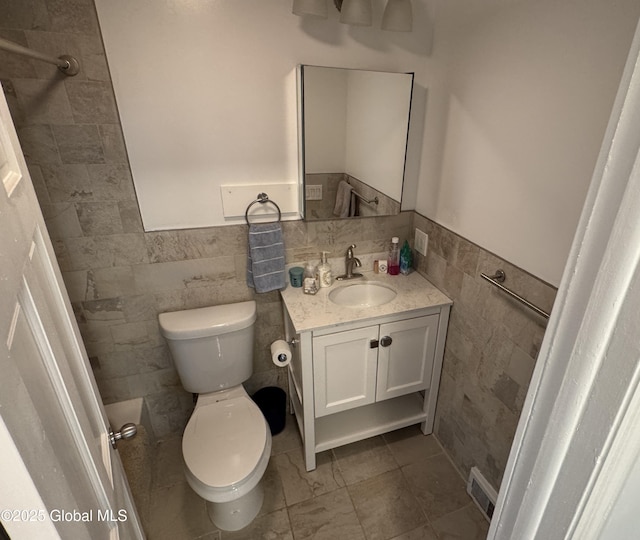 15 Campus View Dr, Colonie, NY 12211 - bathroom featuring tile walls, toilet, vanity, and a wainscoted wall