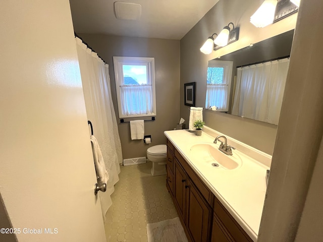 bathroom featuring vanity, plenty of natural light, toilet, and visible vents