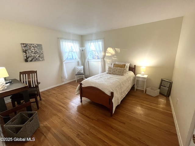 bedroom with baseboards and wood finished floors