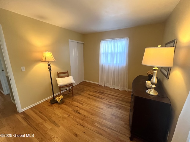 living area featuring baseboards and wood finished floors