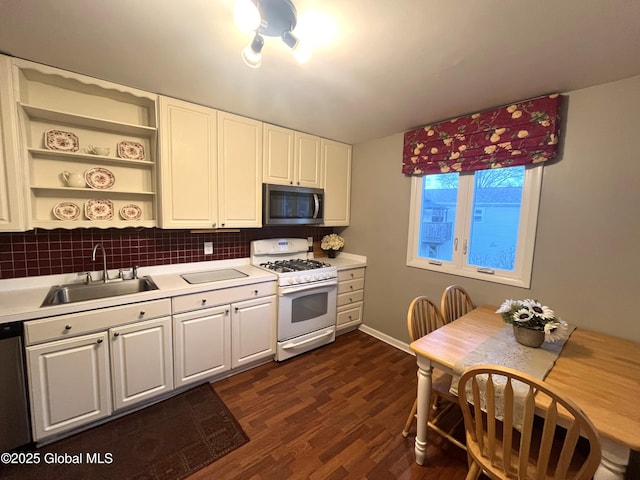 kitchen featuring a sink, open shelves, appliances with stainless steel finishes, and light countertops