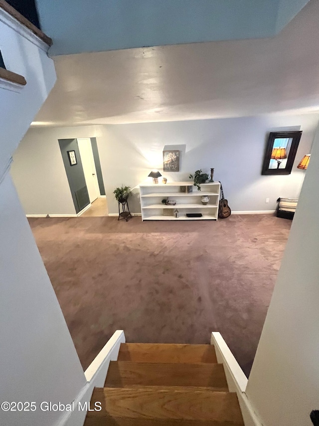 stairway featuring baseboards and carpet