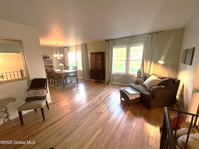 living room featuring baseboards, wood finished floors, and a chandelier