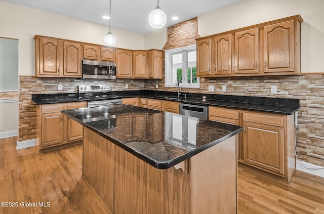 23 Jarose Pl, Clifton Park, NY 12065 - kitchen featuring appliances with stainless steel finishes, light wood finished floors, a sink, tasteful backsplash, and decorative light fixtures