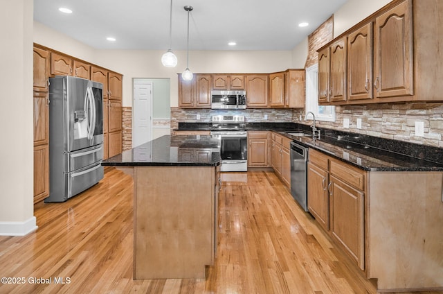 23 Jarose Pl, Clifton Park, NY 12065 - kitchen with appliances with stainless steel finishes, dark stone counters, a center island, light wood-style flooring, and tasteful backsplash