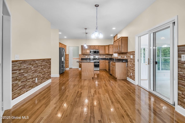 23 Jarose Pl, Clifton Park, NY 12065 - kitchen with stainless steel appliances, light wood finished floors, a kitchen island, dark countertops, and brown cabinetry