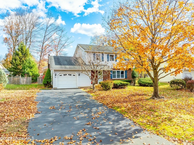 view of front of home featuring a garage, fence, and driveway