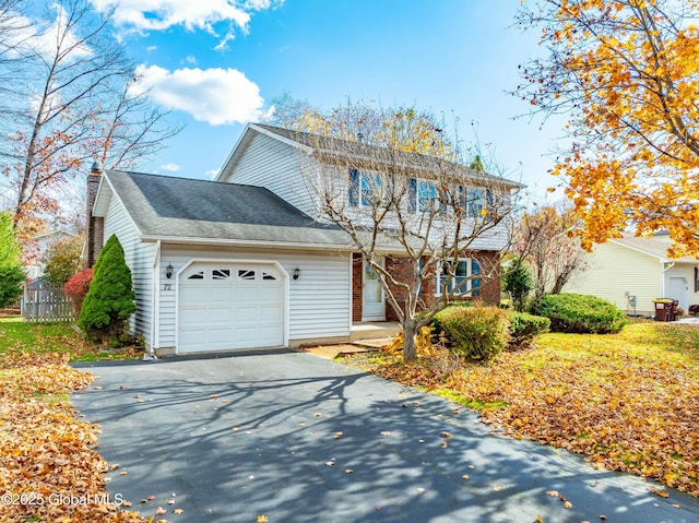 traditional-style home featuring driveway, a chimney, and an attached garage