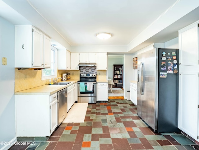 kitchen featuring a sink, under cabinet range hood, backsplash, light countertops, and appliances with stainless steel finishes
