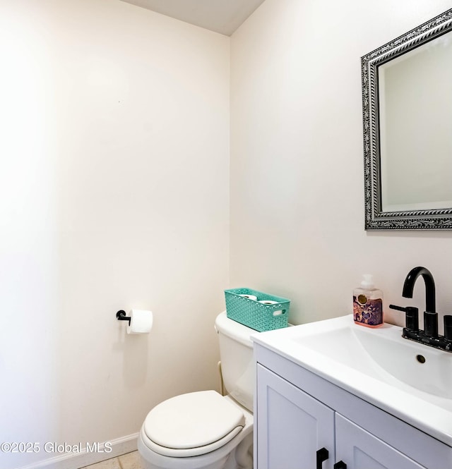 bathroom featuring toilet, vanity, and baseboards
