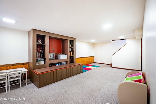 game room with wooden walls, a wainscoted wall, carpet flooring, and built in features